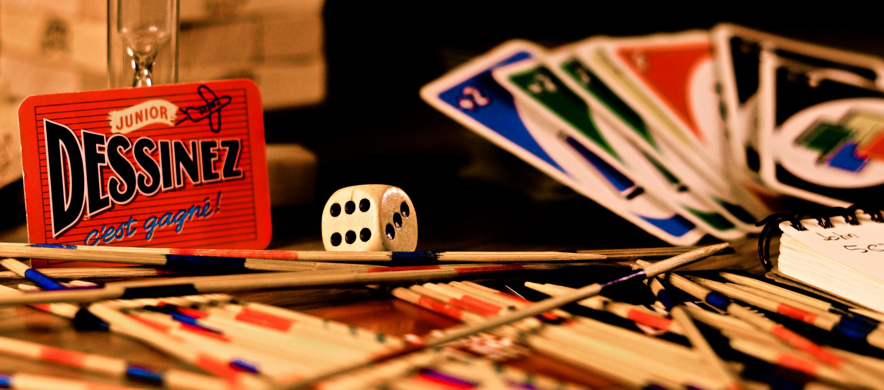 Table avec des jeux de société colorés, cartes et dés